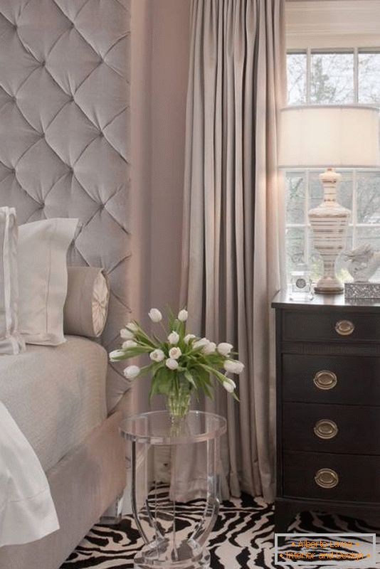 Elegantna spavaća soba s neobičnim tepihom i prozirnim stolom
