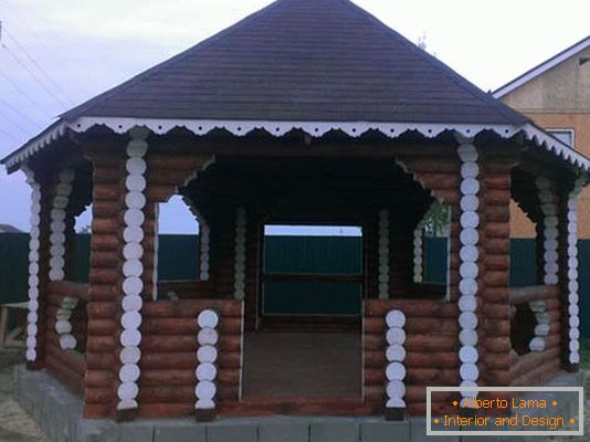 Struktura drvene kuće je klasična opcija za ukrašavanje dvorišta vile u zemlji.