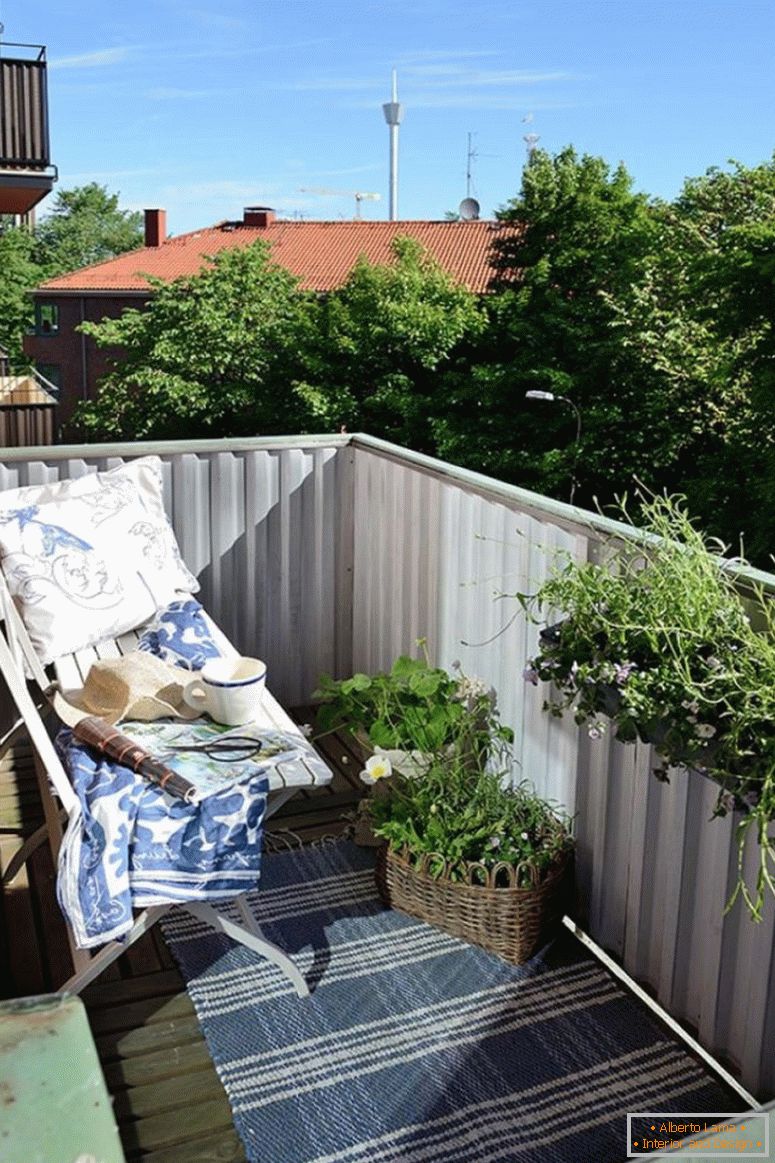 mali vrt-dizajn-sa-bijelom-klupa-i-plavo-amrelčina-tepih-uzorak-pored-bijelo-balkon-ograda