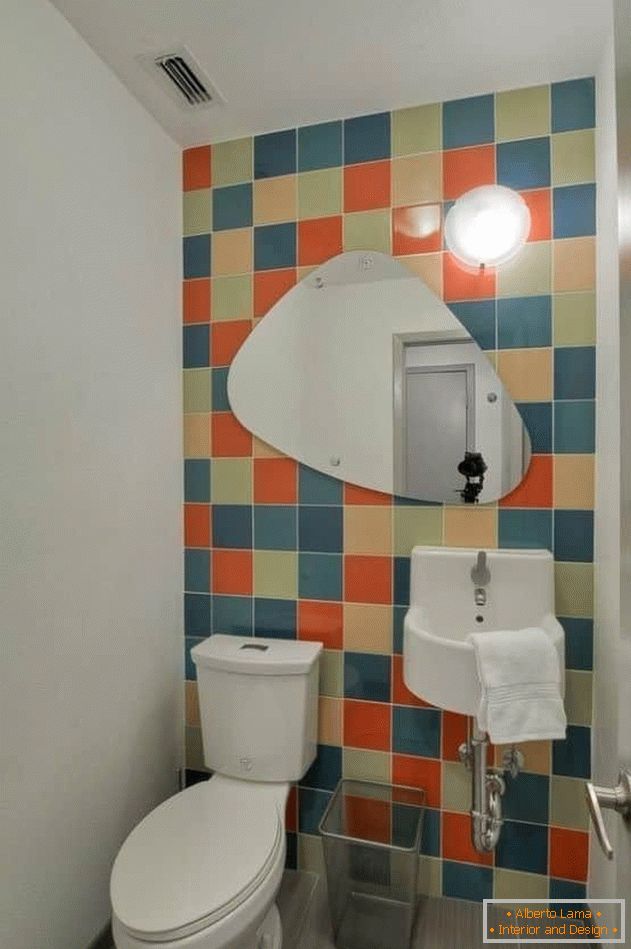 Mali WC s svijetlim pločicama i obojenim zidovima