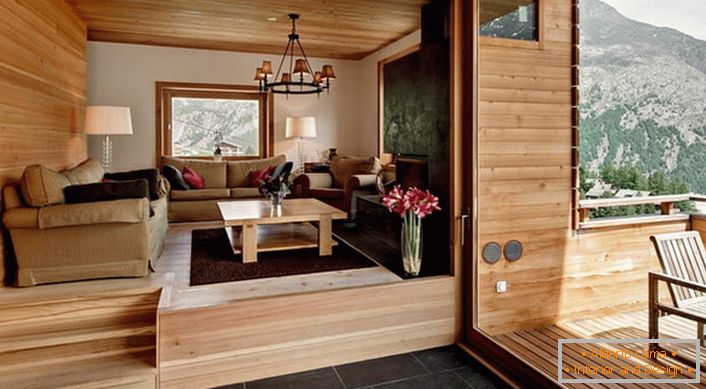 Potkrovlje vile s pristupom na verandu uređeno je u stilu planinske kuće. Boja svijetlog drveta izgleda profitabilna u kombinaciji s tamnosmeđim podnim pločicama.