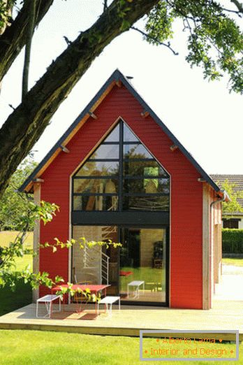 Unutrašnjost male drvene kuće s velikim prozorima