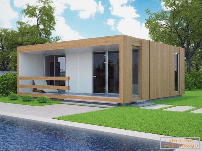 Mala modularna kuća s bazenom u dvorištu. Moderan dizajn kuće koji se brzo gradi izgleda organski u pozadini kratkog izrezbarenog travnjaka.