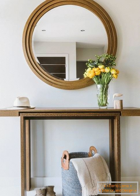 Okruglo ogledalo u hodniku s drvenim oblogama