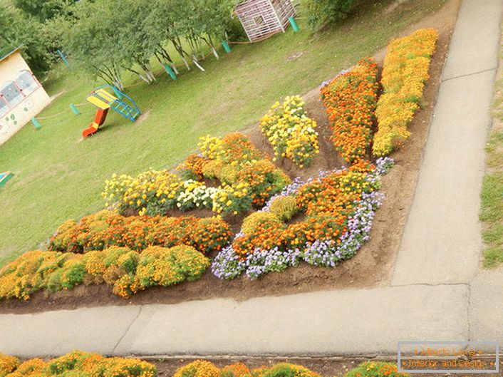 Modularni cvjetni vrt u obliku sunčevog zračenja izgleda skladno na igralištu.