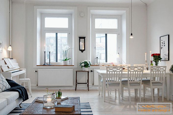Elegantni dnevni boravak je podijeljen na prostor za sjedenje i blagovaonu. U skladu s skandinavskim stilom, zidovi sobe su uređeni u bijeloj boji.