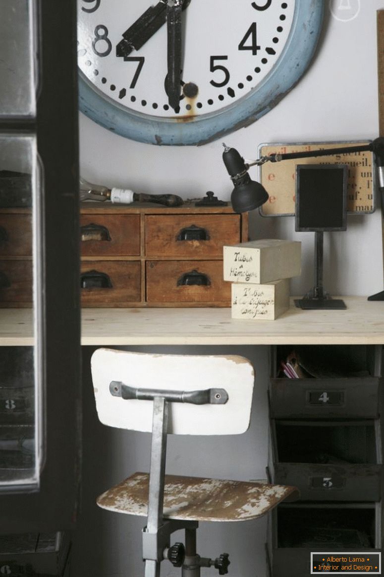 Stari sat postaje iznad starog pisaćeg stola s drvenim kutijama organizatora i drvenom okretnom stolicom s pilingom boje