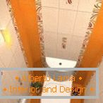 Kombinacija bijelih i narančastih pločica u dizajnu WC-a