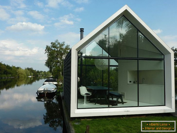 Mala staklena kuća u blizini jezera u Nizozemskoj