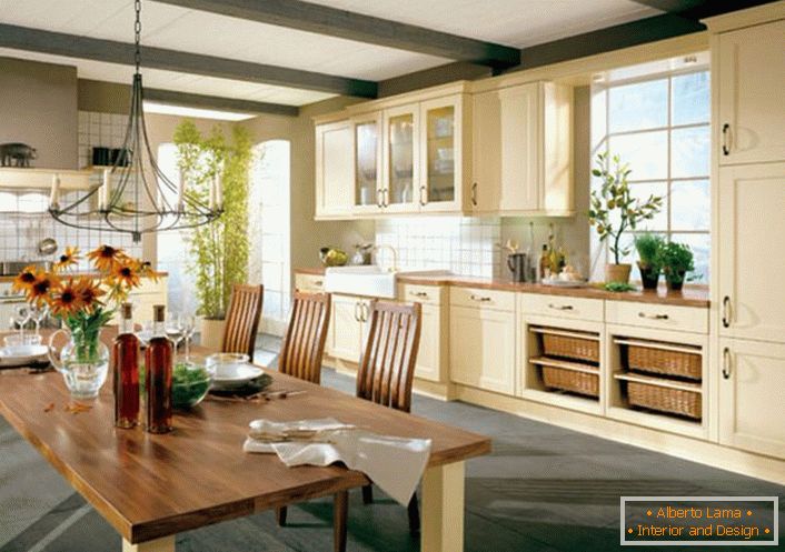 Kuhinja u stilu zemlje u velikom domu talijanske obitelji. Za stilu zemlje, kuhinjski set drveta u svijetlim bež tonovima dobro je odabran.