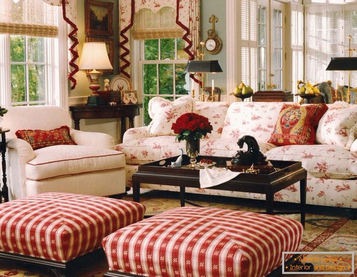 Jednostavan, skroman i ugodan dnevni boravak u engleskom stilu u maloj kući. Akcenti crvene čine atmosferu u sobi opušteni i veseli.