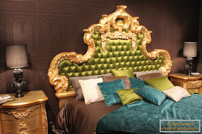 Visok ornatni natrag u glavu kreveta prekriven je maslinastom svilom. Zanimljivi jastuci s kontrastnim bojama i pokrivačima na krevetu.
