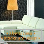 Narančasta podna svjetiljka pored bijele sofe
