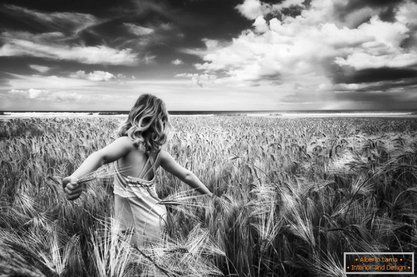 Crna i bijela fotografija djevojke u polju pšenice