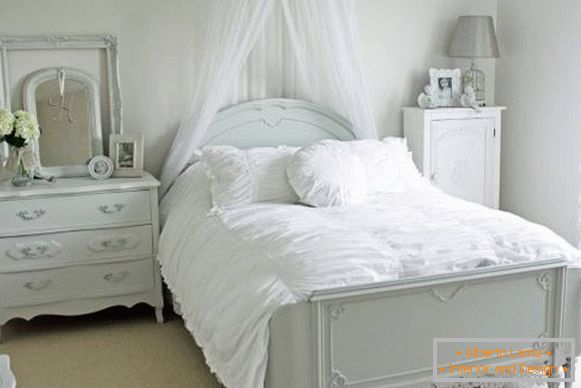 Romantična spavaća soba s bijelim krevetom i dekorom