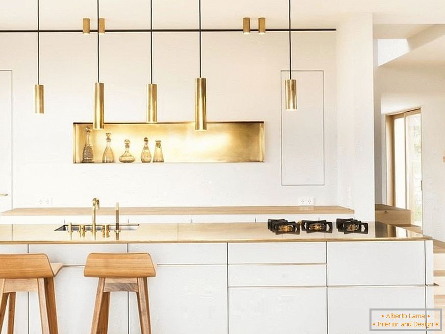 Zlatni elementi dekor u bijeloj kuhinji s drvenim stolcima