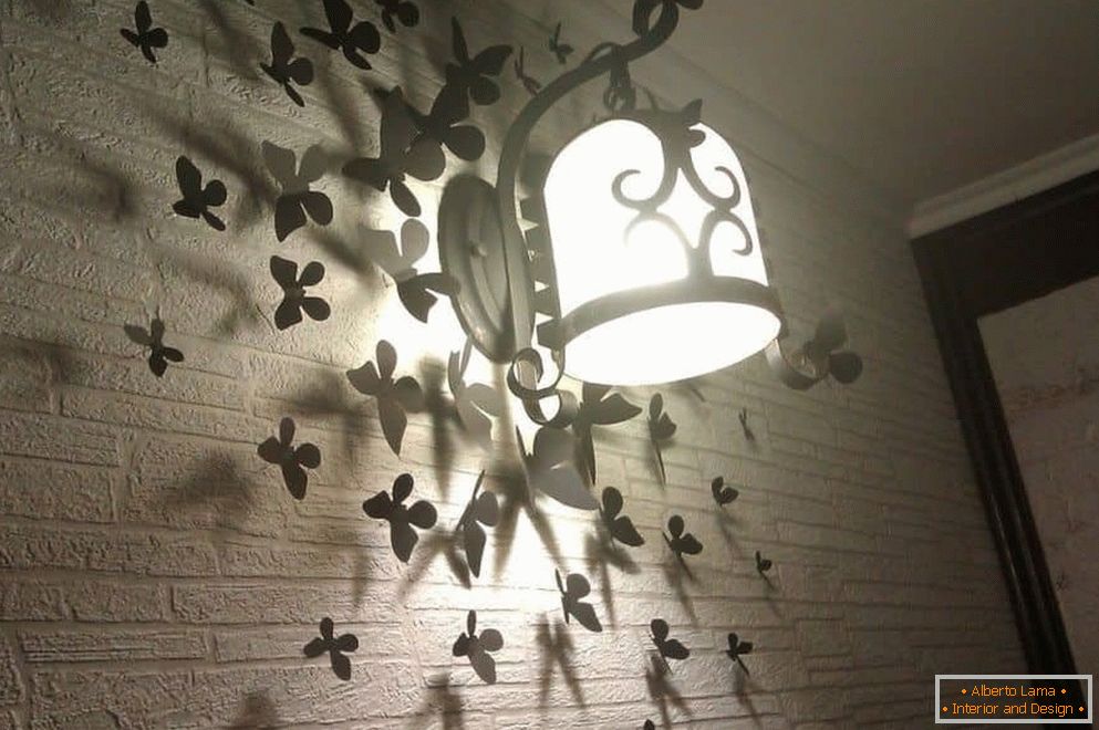 Leptiri na zidu s svjetiljkom