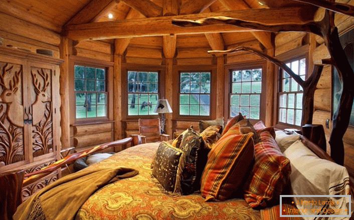 Jedna od spavaćih soba u kući u blizini jezera je napravljena u stilu seoske zemlje. Drveni ukras. Masivni namještaj i dekor elementi odabrani su u najboljim stilskim tradicijama.