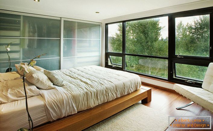 Niski krevet od drveta skladno se uklapa u unutrašnjost spavaće sobe u secesijskom stilu.