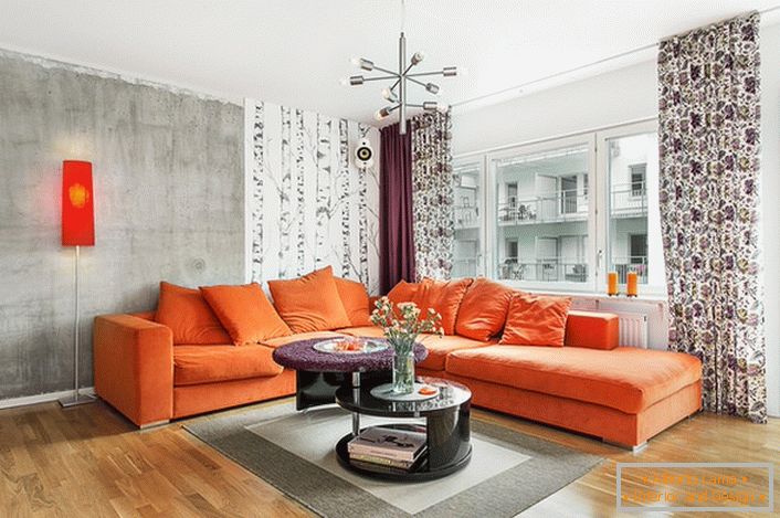 Skandinavski je stil inherentan korištenju toplih boja u dizajnu interijera. Sofija sofisticirane naranče organski gleda na pozadinu zidova hladne sive boje.