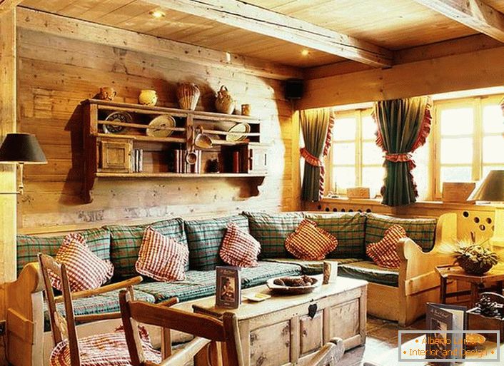 Drveni zidni ukras, kontrastni jastuci na mekom sofu, guste zavjese s rukavima na prozorima. Ugodan dnevni boravak u rustikalnom stilu u seoskom domu.