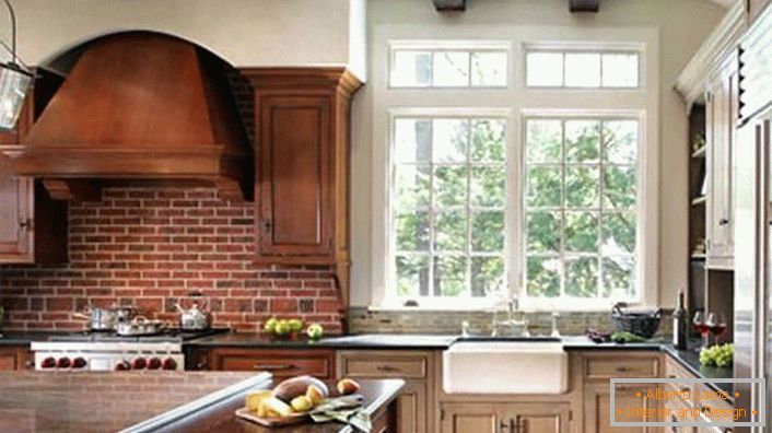 Ispravno uređena kuhinja u rustikalnom stilu. Kuhinjski ormarić i tamno drvo kombiniraju se sa zidom, postavljenim od opeke.