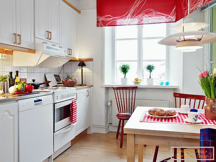 Bijela boja u kombinaciji s plemenitom crvenom bojom vizualno povećava kuhinju. Svijetli, zasićeni naglasci čine sobu moderan i kreativan. 