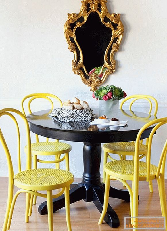 Svijetle žute stolice i crni stol za blagovanje