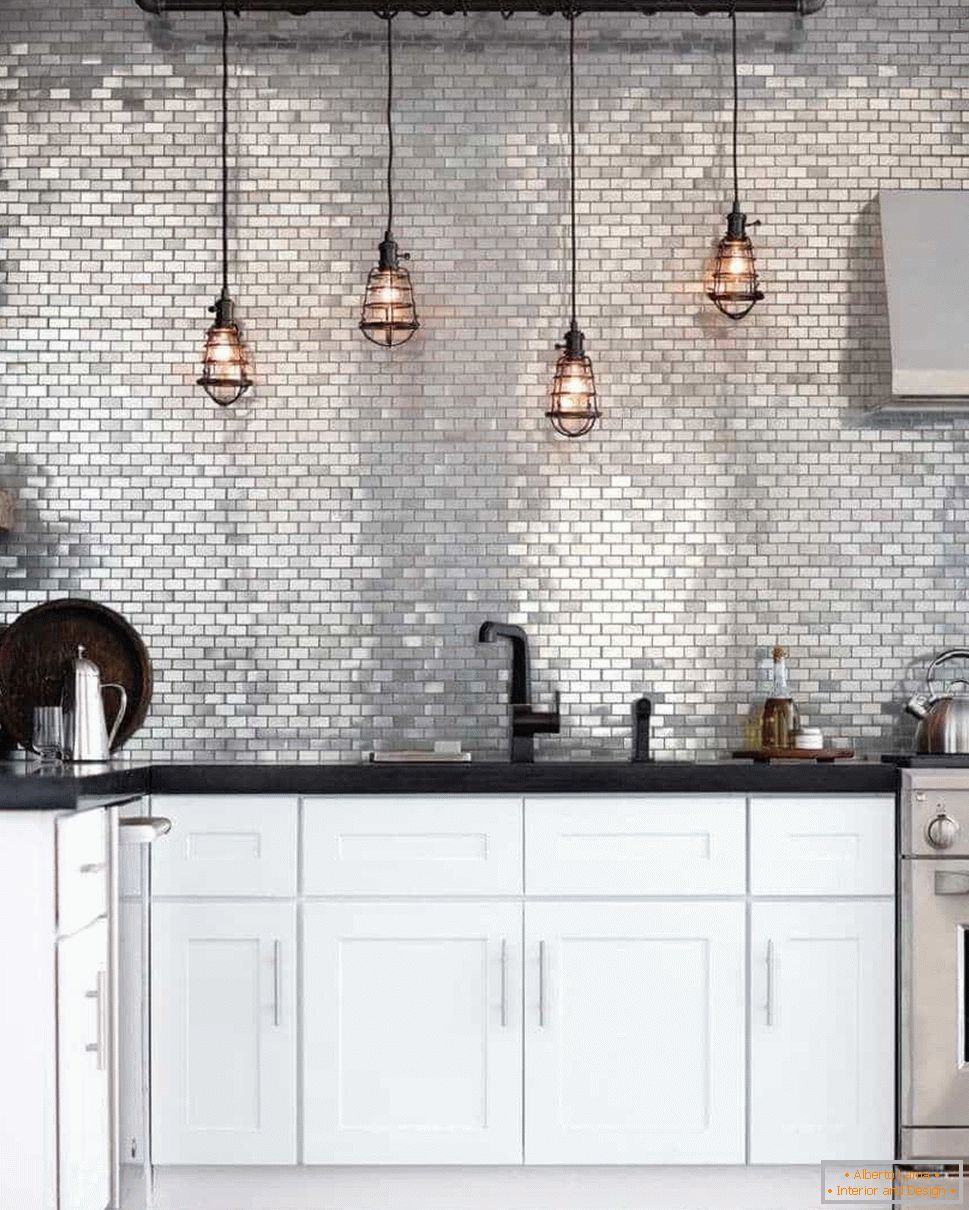 Kuhinja u stilu grunge s pregačom od srebrne boje i retro svjetla iznad radnog prostora