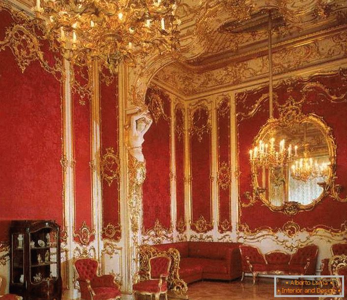 Dnevni boravak u kući pravilno je ukrašen crvenim namještajem. Plemenit crvena je savršeno kombinirana sa zlatnim elementima.