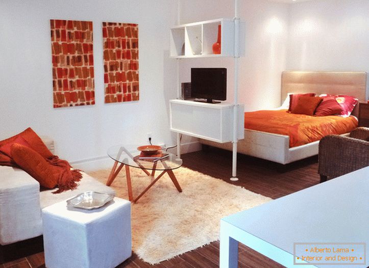Unutrašnjost bijelog studio apartmana s narančastim naglascima